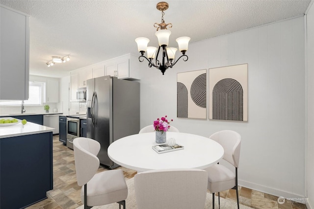 dining area featuring a notable chandelier and a textured ceiling