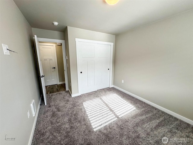 unfurnished bedroom with baseboards, carpet floors, a closet, and visible vents