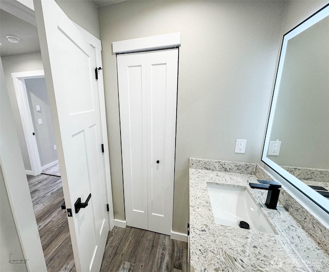 bathroom featuring baseboards, wood finished floors, and vanity