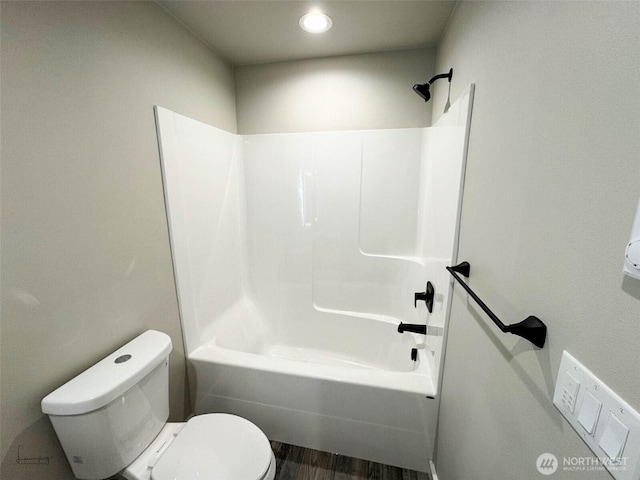 full bath featuring toilet, wood finished floors, and tub / shower combination