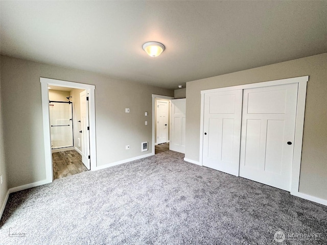 unfurnished bedroom featuring visible vents, connected bathroom, baseboards, carpet floors, and a closet