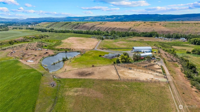 aerial view featuring a water and mountain view and a rural view