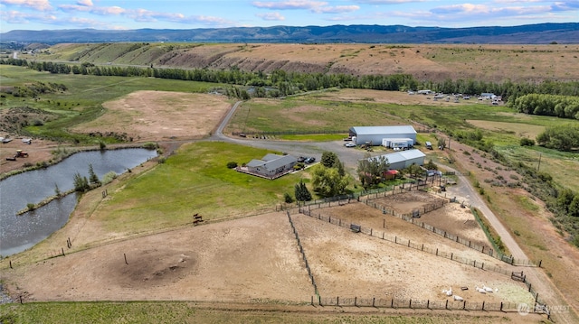 drone / aerial view featuring a water and mountain view and a rural view