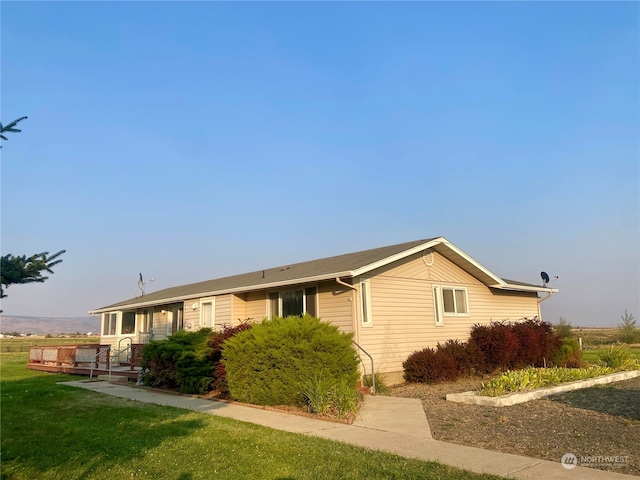 view of front of home featuring a wooden deck and a front lawn