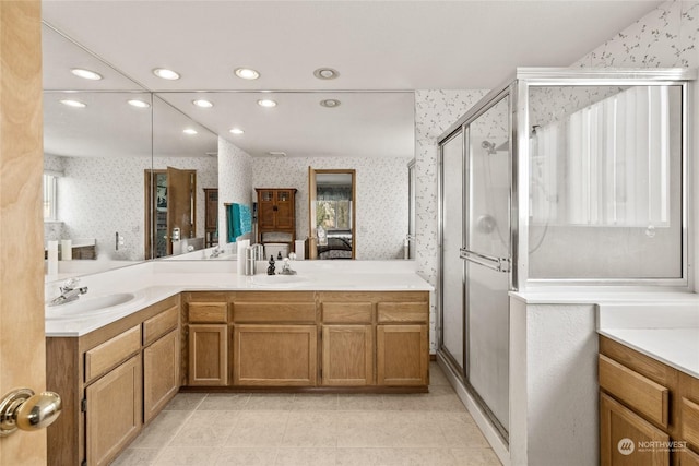 ensuite bathroom featuring connected bathroom, wallpapered walls, and a sink