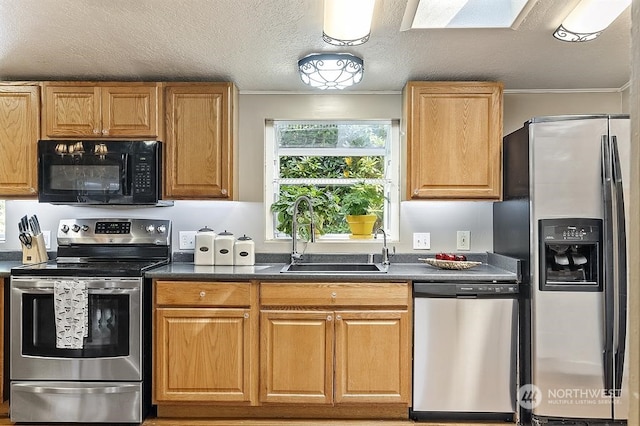 kitchen featuring crown molding, stainless steel appliances, dark countertops, a sink, and a textured ceiling