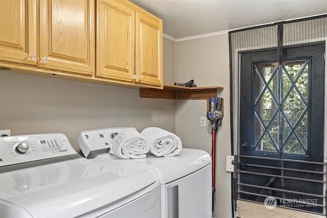 clothes washing area featuring a textured ceiling, ornamental molding, washing machine and clothes dryer, and cabinet space