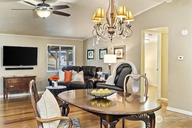 dining area featuring vaulted ceiling, crown molding, baseboards, and wood finished floors