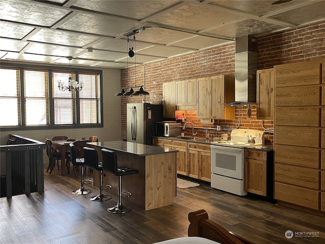 kitchen featuring a breakfast bar area, stainless steel fridge, a center island, dark wood-type flooring, and white range with electric stovetop