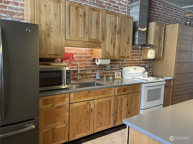 kitchen featuring sink, stainless steel appliances, wall chimney exhaust hood, and brick wall