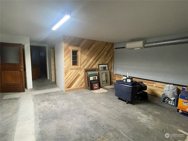 garage with wood walls and a wall mounted AC