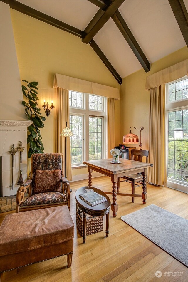 dining space featuring beamed ceiling, light hardwood / wood-style flooring, and high vaulted ceiling