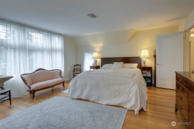 bedroom featuring lofted ceiling and light hardwood / wood-style flooring