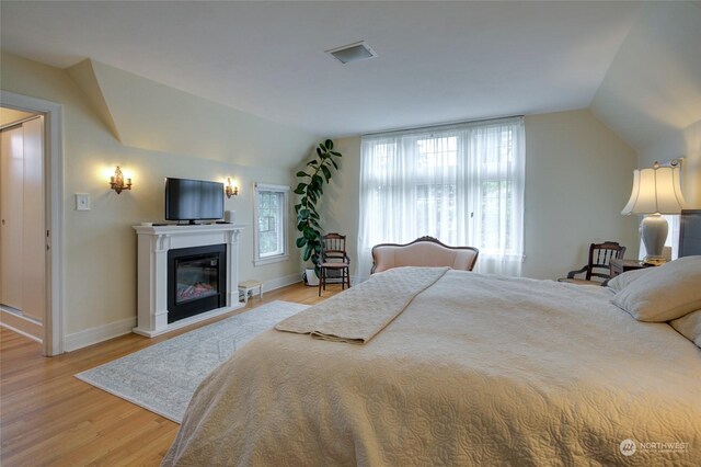 bedroom with lofted ceiling and light hardwood / wood-style floors