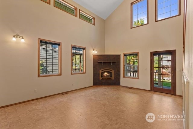 unfurnished living room with a fireplace and high vaulted ceiling