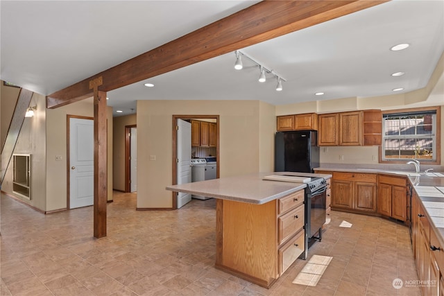 kitchen featuring beamed ceiling, stainless steel electric stove, washer and dryer, a center island, and black refrigerator