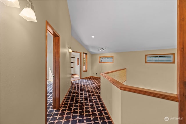 corridor with carpet flooring and vaulted ceiling