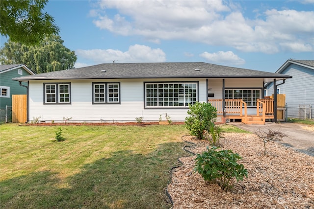 single story home featuring a deck and a front lawn