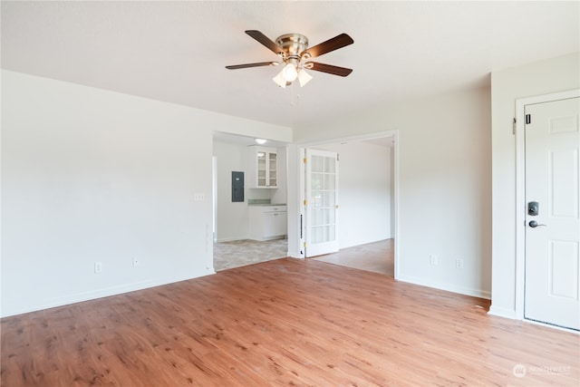 empty room featuring light hardwood / wood-style flooring, electric panel, and ceiling fan