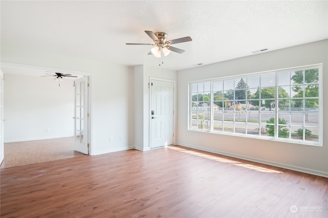 spare room with a textured ceiling, wood-type flooring, and ceiling fan