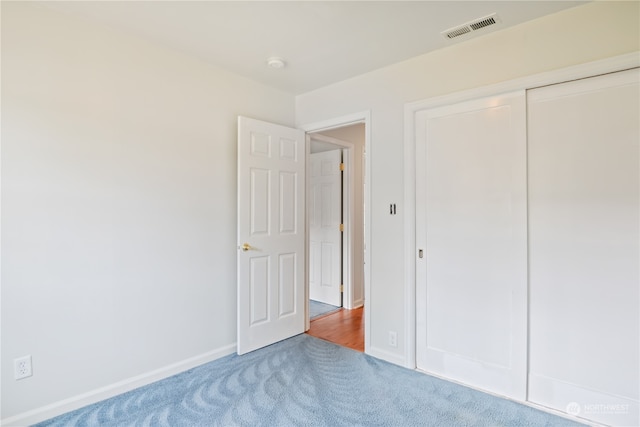 unfurnished bedroom with carpet flooring and a closet