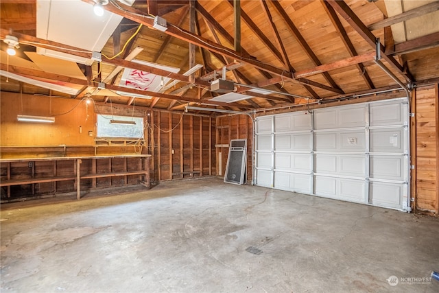 garage with a garage door opener and wooden walls