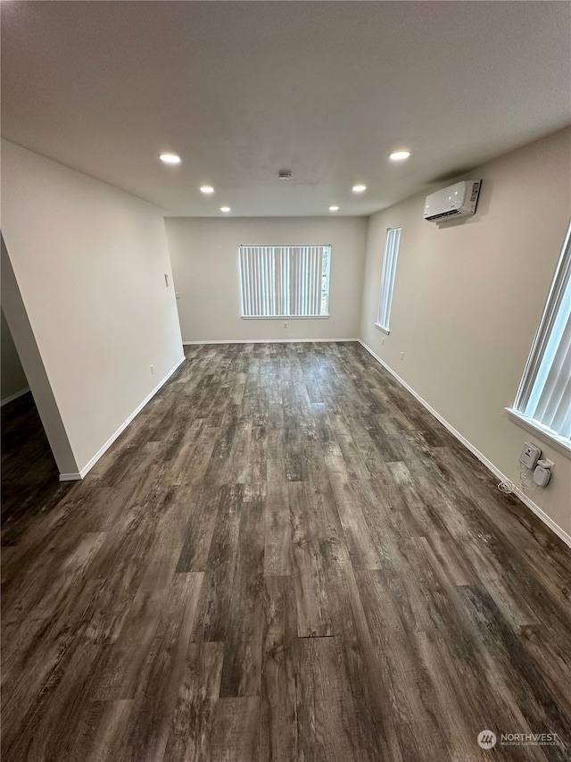 interior space featuring dark wood-type flooring and an AC wall unit