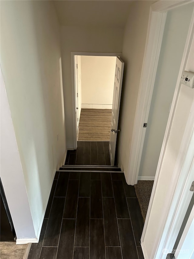 corridor with dark hardwood / wood-style flooring