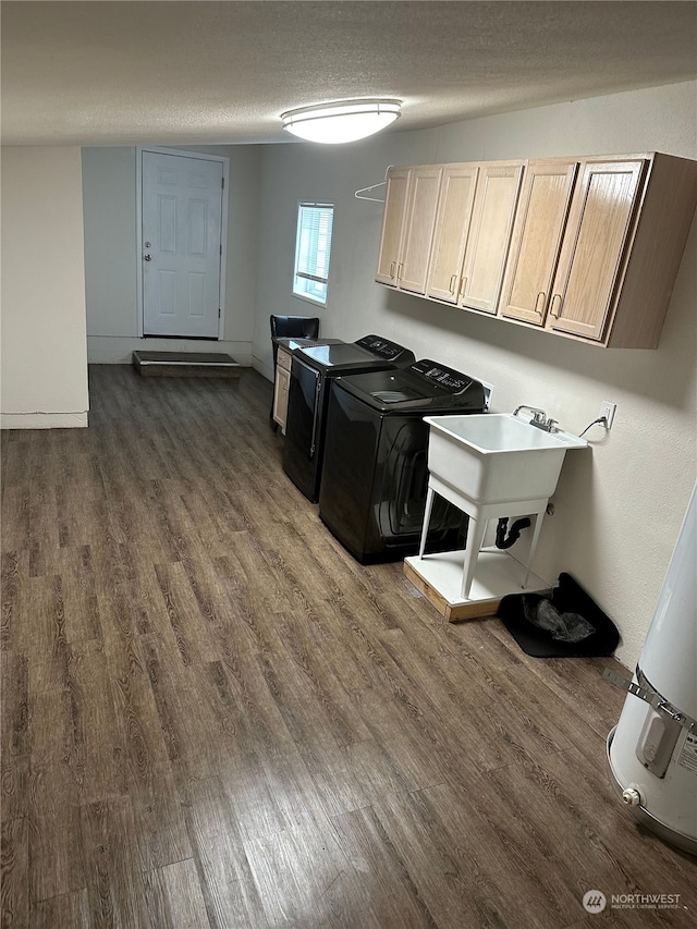 clothes washing area featuring cabinets, dark wood-type flooring, a textured ceiling, and washer and dryer