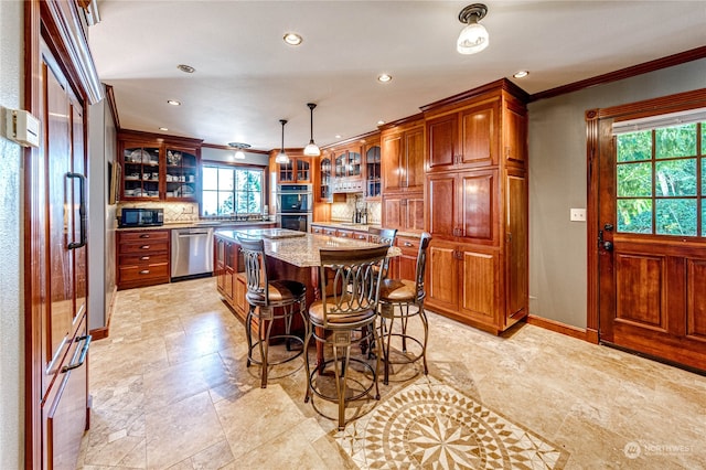 kitchen with hanging light fixtures, a center island, appliances with stainless steel finishes, light stone counters, and a kitchen breakfast bar