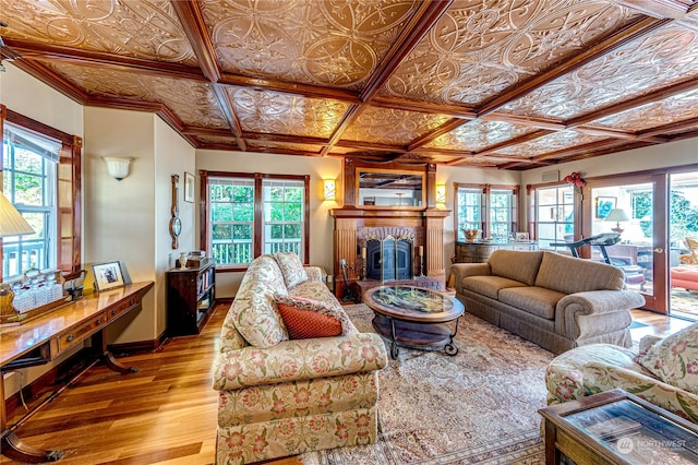 living room with light hardwood / wood-style flooring, coffered ceiling, and a brick fireplace