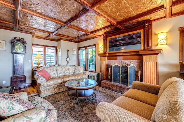 living room with coffered ceiling, hardwood / wood-style flooring, and a fireplace