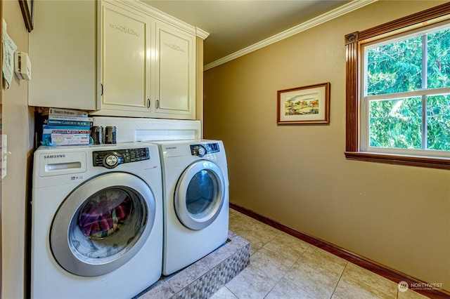 laundry room featuring ornamental molding, cabinets, washing machine and dryer, and light tile patterned flooring