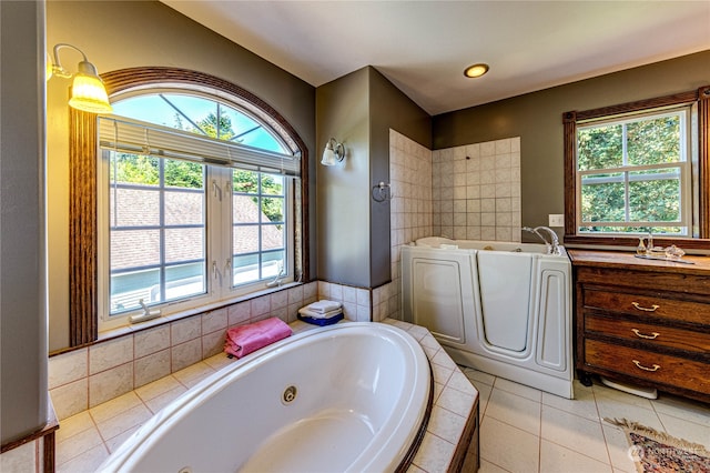 bathroom with vanity, tiled tub, and tile patterned floors