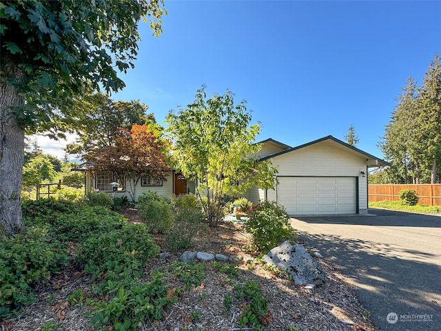 view of property hidden behind natural elements featuring a garage