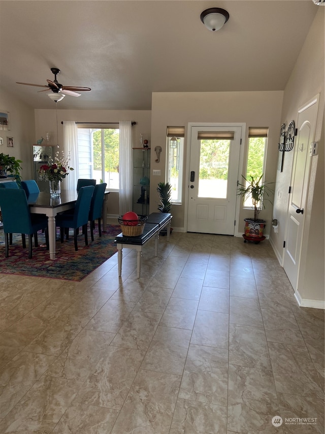 foyer entrance with ceiling fan, a healthy amount of sunlight, and vaulted ceiling