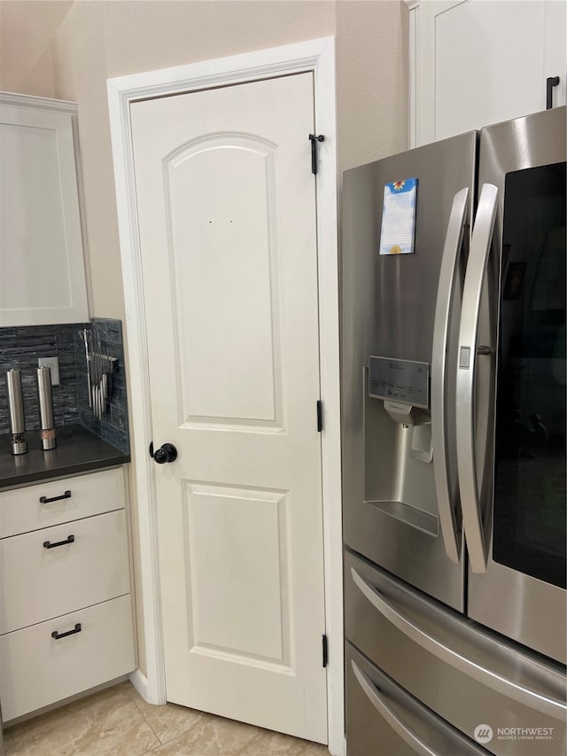 kitchen featuring white cabinetry, stainless steel refrigerator with ice dispenser, and decorative backsplash