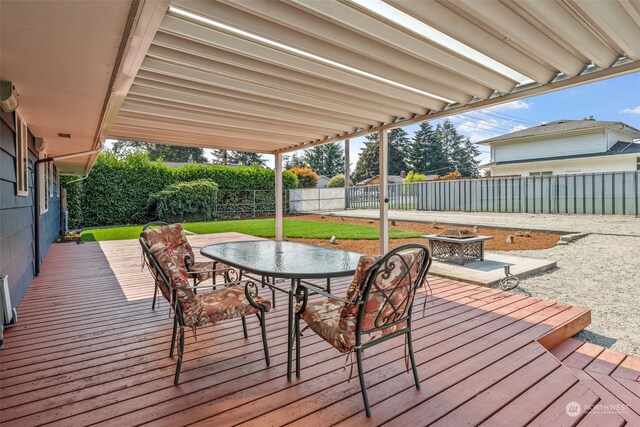 wooden deck with a yard and a fire pit