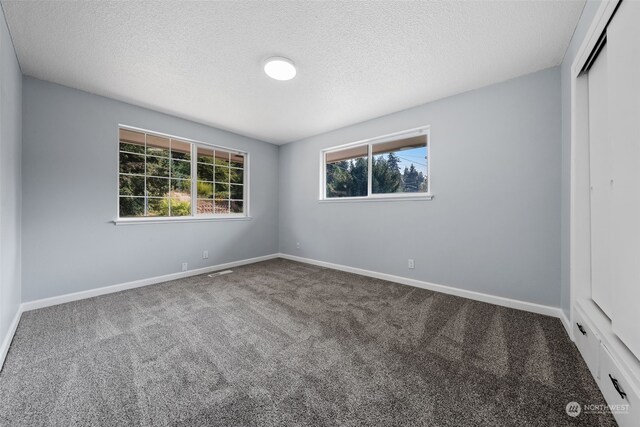 unfurnished bedroom featuring a closet, a textured ceiling, and carpet flooring