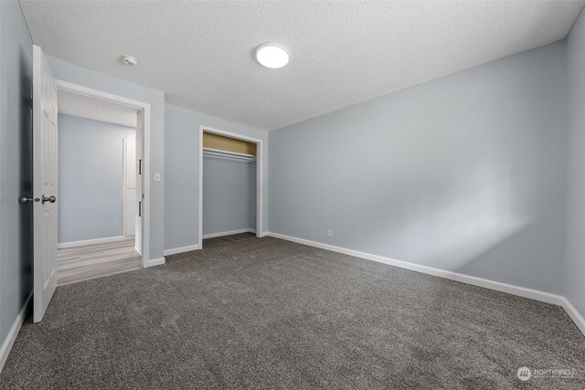 unfurnished bedroom featuring carpet flooring, a textured ceiling, and a closet