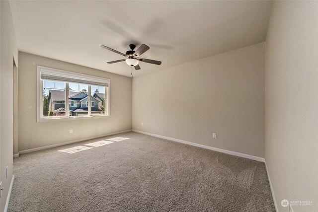 carpeted spare room featuring ceiling fan