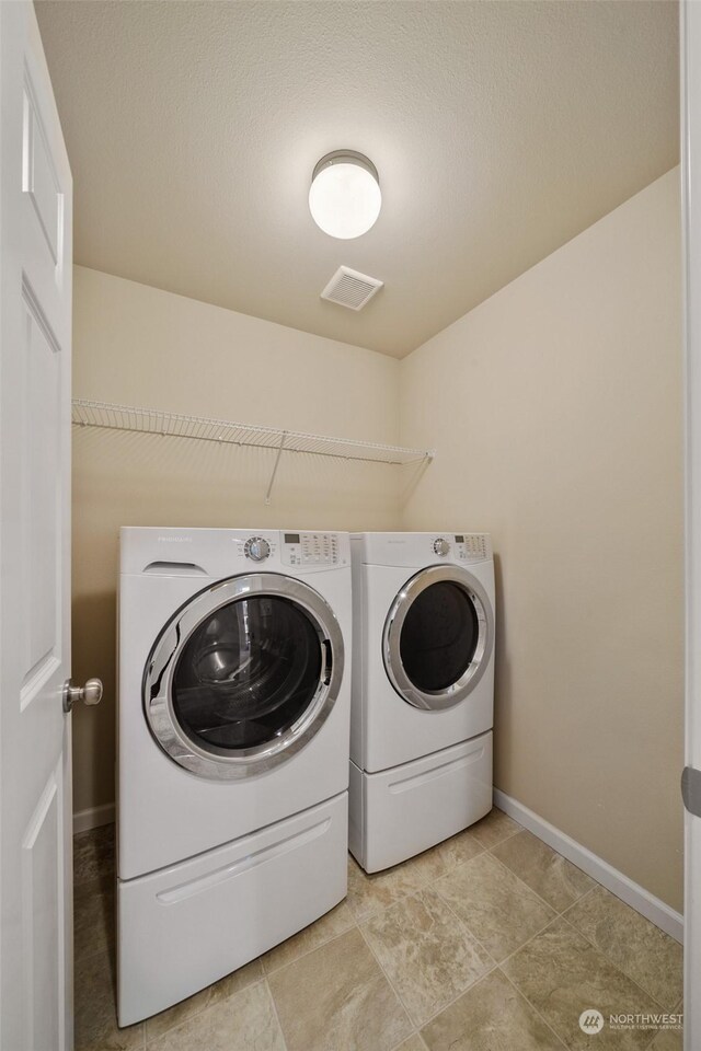 laundry room featuring a textured ceiling and independent washer and dryer