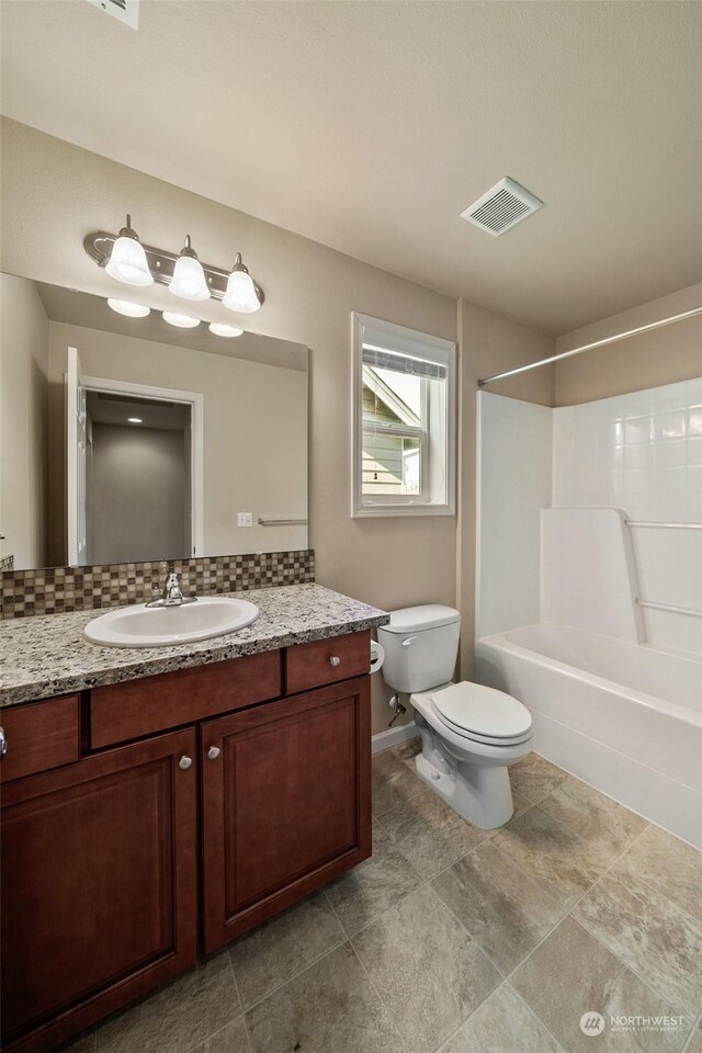 full bathroom with tile patterned floors, toilet, decorative backsplash, shower / bathing tub combination, and vanity