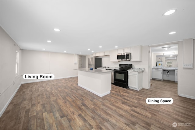 kitchen with stainless steel appliances, white cabinetry, and dark hardwood / wood-style floors