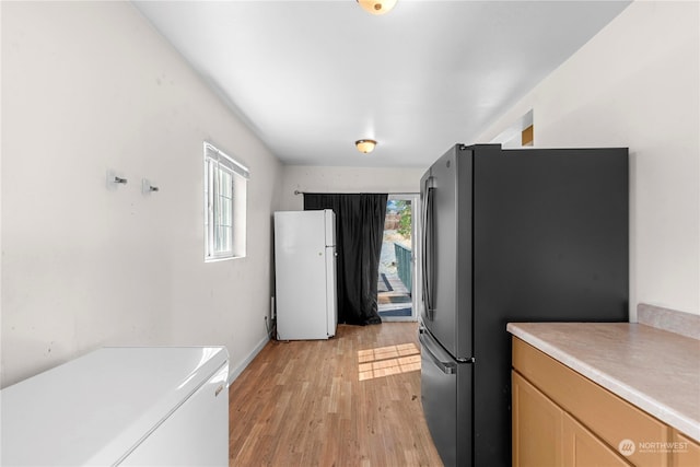 kitchen featuring stainless steel fridge, white refrigerator, and light hardwood / wood-style floors