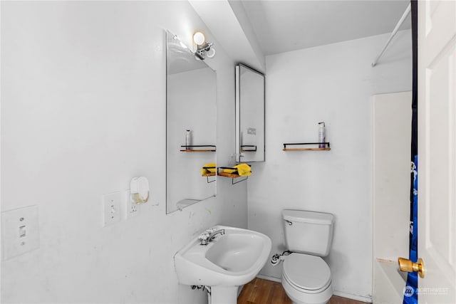 bathroom with toilet, sink, and hardwood / wood-style floors