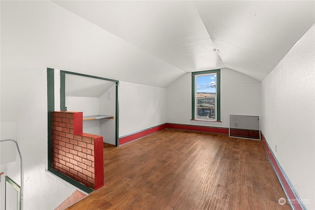 bonus room featuring vaulted ceiling and dark hardwood / wood-style flooring