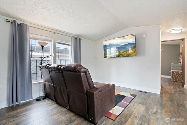 living area with lofted ceiling, dark wood-style floors, baseboards, and a textured ceiling