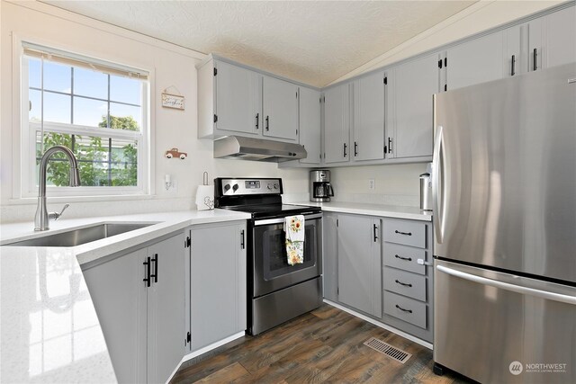 13708 108th Street Ct E Unit 4, Puyallup, WA 98374 - kitchen featuring visible vents, under cabinet range hood, a sink, a textured ceiling, and appliances with stainless steel finishes