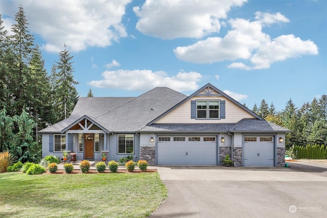 craftsman inspired home featuring a garage and a front lawn